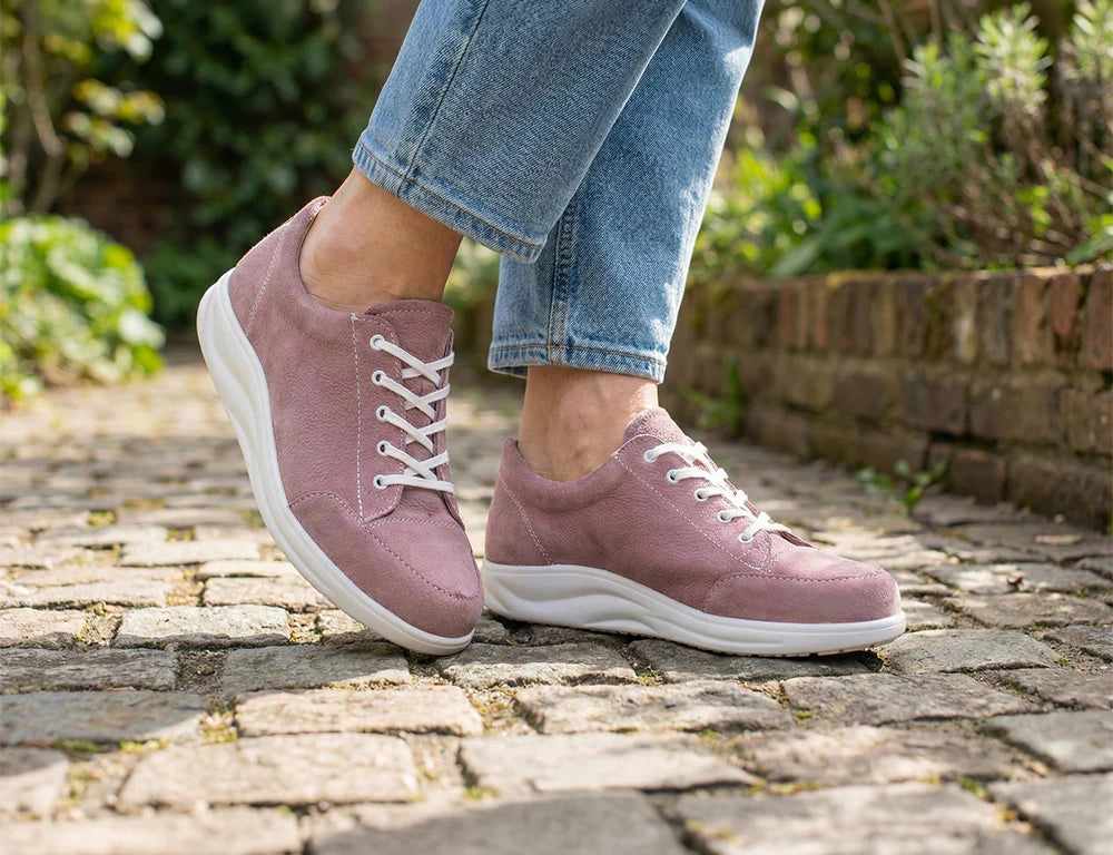  Women wearing Finn Comfort Womens's pink sneakers on a stone path with a garden background
