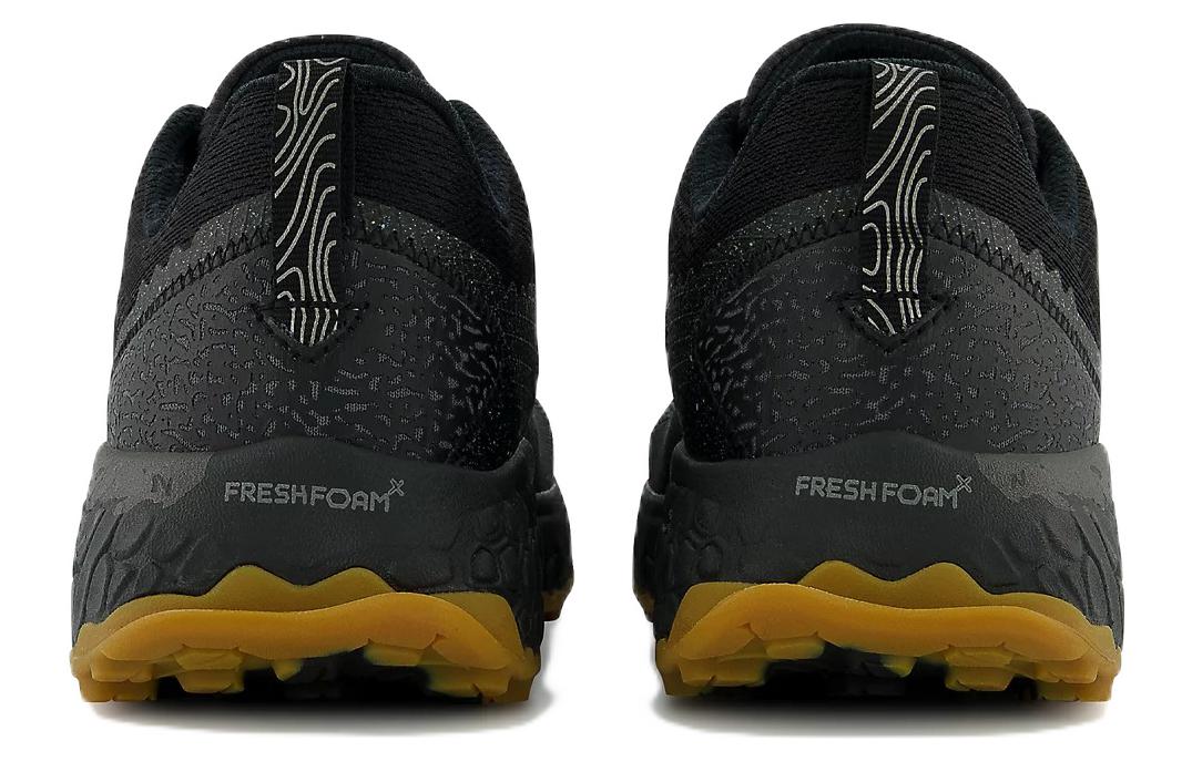 Black running shoes with yellow sole on a white background NEW BALANCE