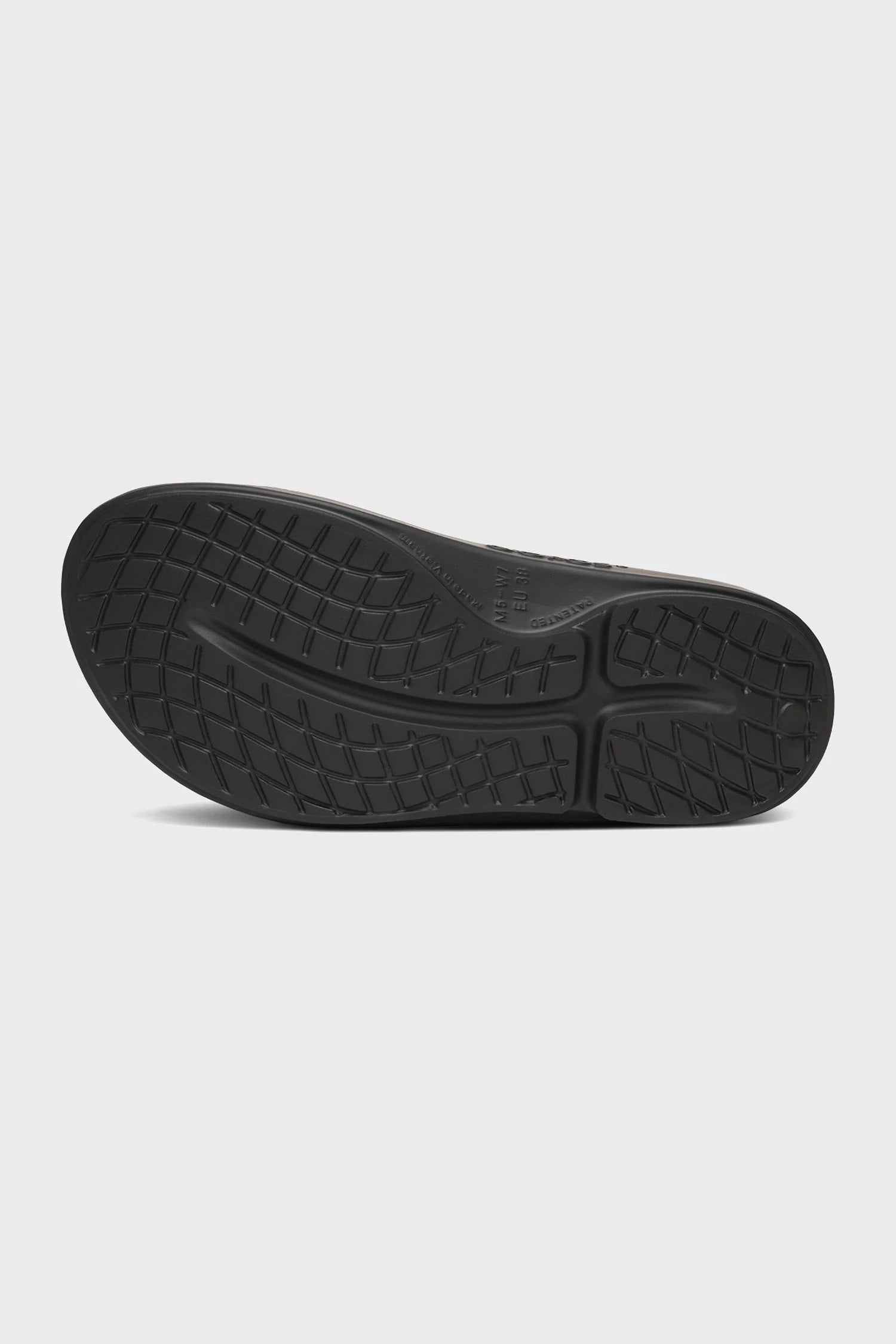 OOFOS OOahh Women's Slide Sandal Pebble Black shoe sole on a light gray background