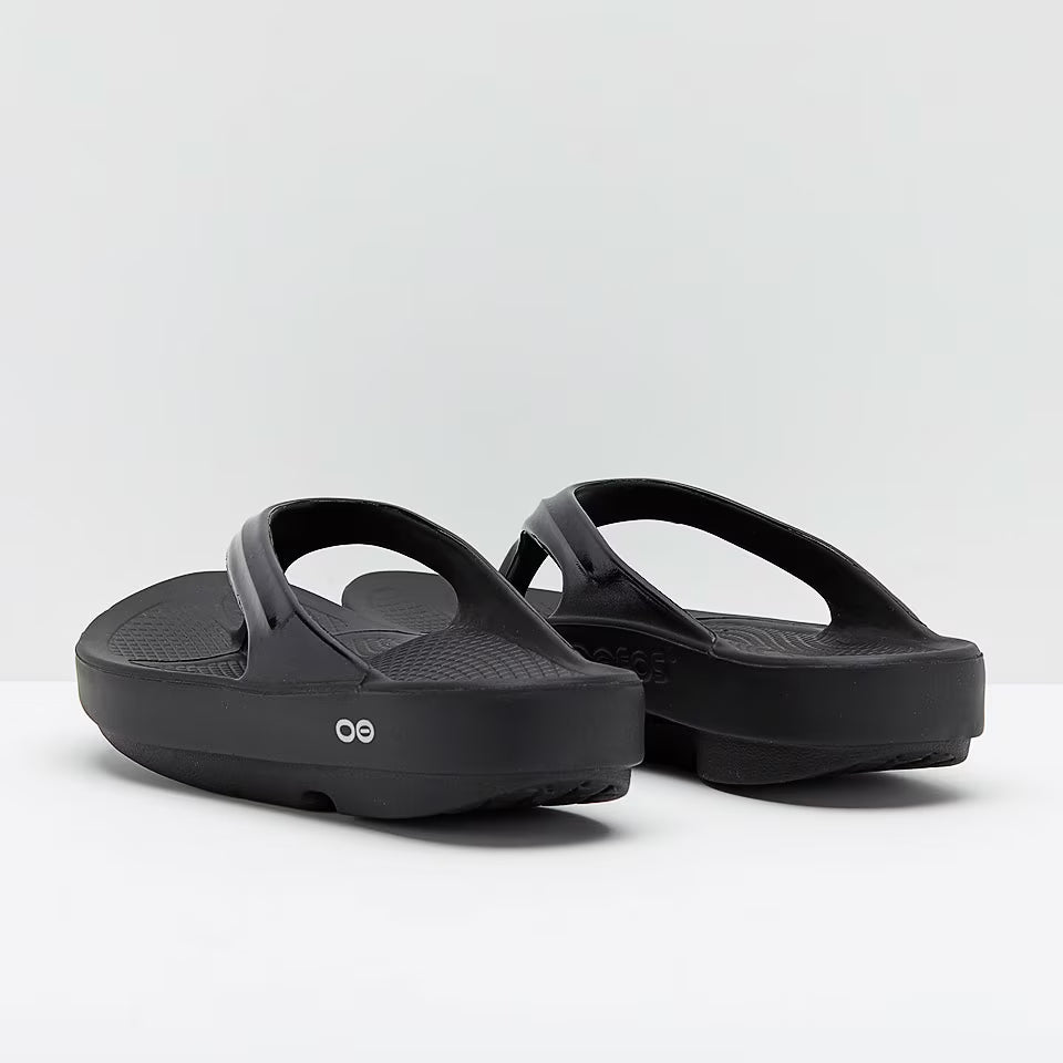 Pair of OOFOS Oolala Recovery Flip-Flops Thong sport active black sandals  on a white background
